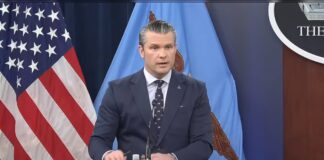 Hegseth Says Iran’s New Supreme Leader Is Wounded, Claims Tehran Has Lost Air Defenses, Air Force and Navy Defense Secretary Pete Hegseth speaking at a Pentagon press briefing podium
