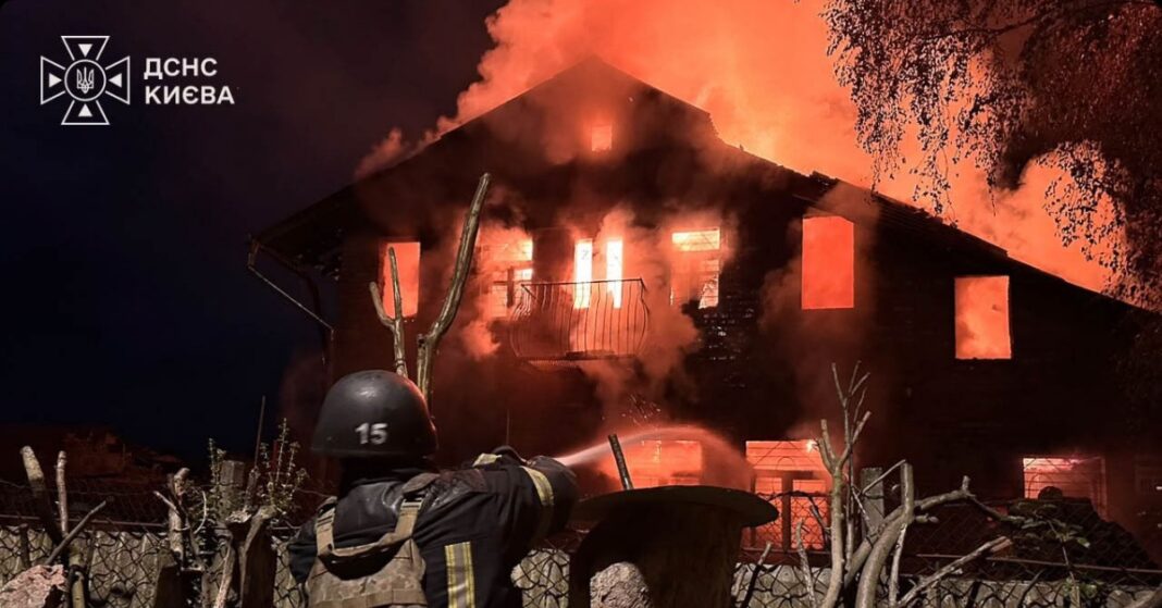 A firefighter sprays water at a burning building in an image shared during reports of Russian strikes on Ukraine.