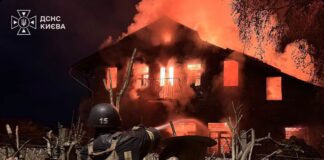 A firefighter sprays water at a burning building in an image shared during reports of Russian strikes on Ukraine.