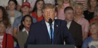 President Donald Trump speaks at a podium bearing the presidential seal