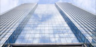 A low-angle view looking up at the glass Barclays headquarters tower, with the blue Barclays sign at the bottom. (Screenshot)