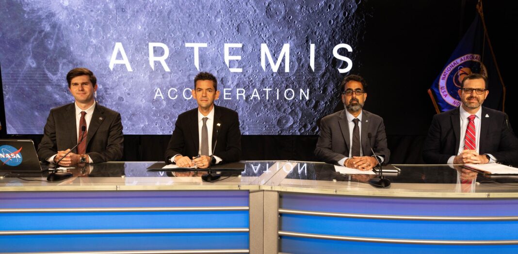 Four NASA officials seated at a news desk in front of an Artemis Acceleration screen showing the Moon's surface