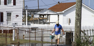 A resident walks along a road covered by tidal floodwater on Tangier Island, Virginia, on Sept. 16, 2016. The file photo illustrates coastal flooding conditions in the Chesapeake Bay region.