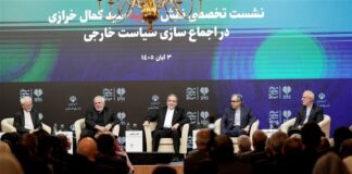 Panelists including Iranian Foreign Minister Abbas Araghchi seated on stage at an IPIS forum in Tehran, before an audience.