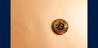 A gold Bitcoin coin on a neutral surface representing the Brooklyn DA crypto scam investigation