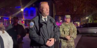 Interim Police Chief Jeff Carroll speaks to reporters about the National Guardsman shot in Southeast Washington, with a National Guard member standing beside him
