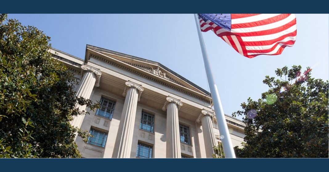 A U.S. flag flies outside a columned federal building in this Justice Department photo.