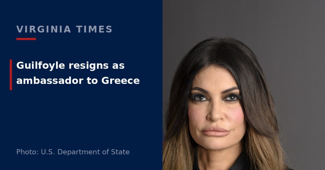 Official portrait of Kimberly Guilfoyle, U.S. ambassador to Greece, wearing a black suit with a U.S. flag behind her