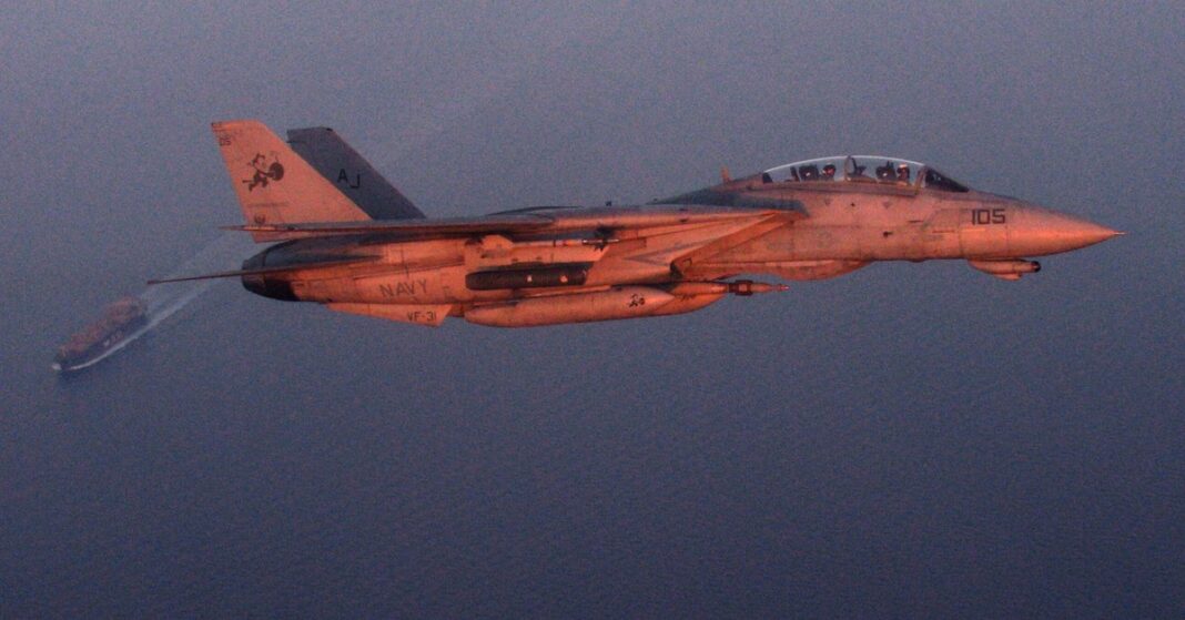 A U.S. Navy jet banks over an oil tanker in the Persian Gulf