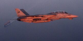 A U.S. Navy jet banks over an oil tanker in the Persian Gulf