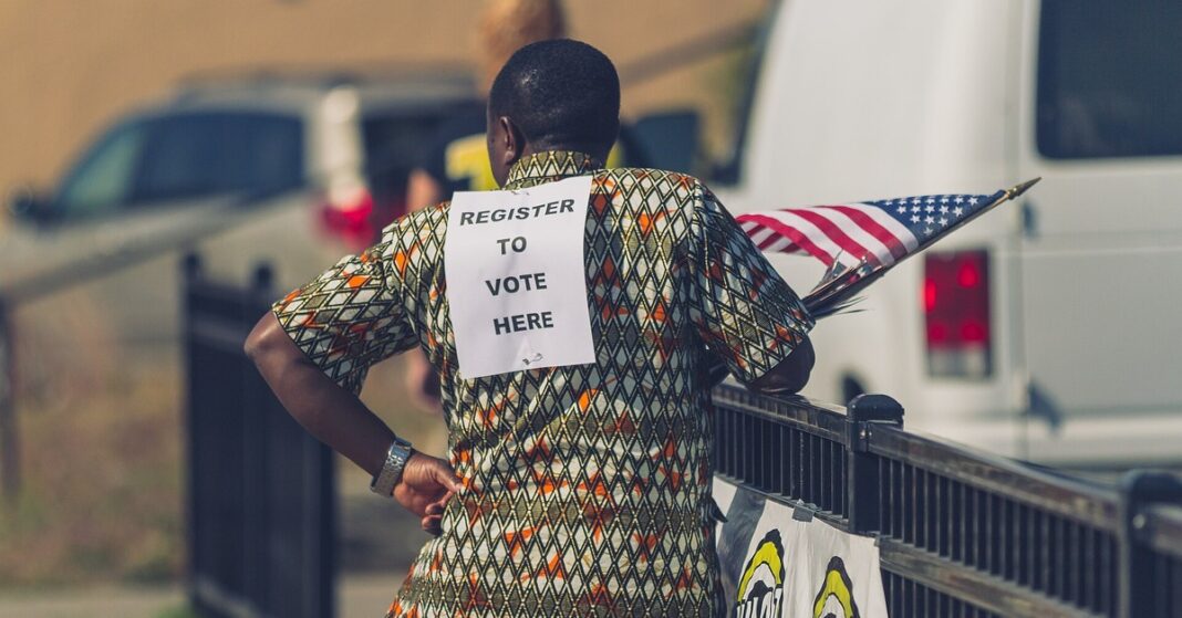 Noncitizen voter subpoenas: a voter registration volunteer wearing a 