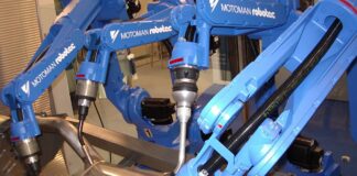 Blue Motoman industrial welding robots on a factory line, illustrating the Trump robotics tariffs story
