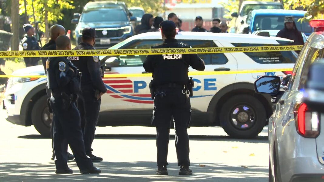 D.C. police officers behind crime-scene tape at the Jabrell Young shooting scene in the 200 block of 46th Street NE.