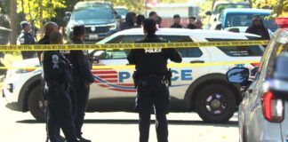 D.C. police officers behind crime-scene tape at the Jabrell Young shooting scene in the 200 block of 46th Street NE.