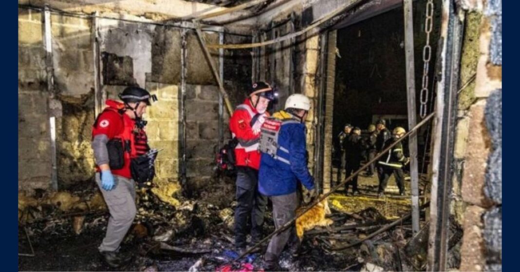 Emergency workers inside a fire-damaged store near Kharkiv after a missile strike.
