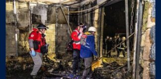 Emergency workers inside a fire-damaged store near Kharkiv after a missile strike.