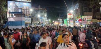 Dense nighttime crowd filling a street in Kolkata during Durga Puja