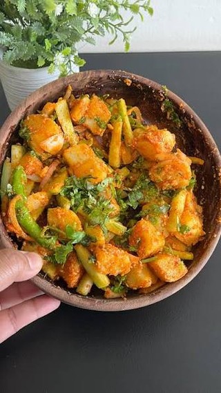 Nepali potato achar with green chilies, cilantro and sliced vegetables in a bowl