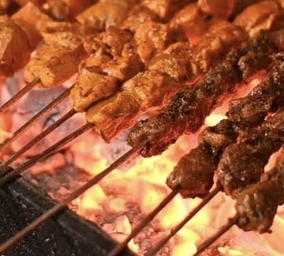 Spiced sekuwa meat skewers grilling over glowing coals