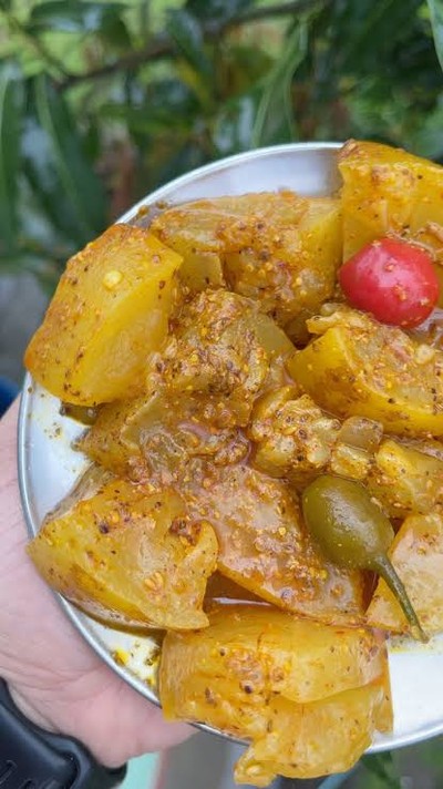 A plate of mature cucumber pickle coated in mustard seeds and spices