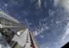 Reliance Says It Welcomes Starlink Competition After Musk Criticism A stack of Starlink satellites atop a Falcon 9 rocket above Earth.