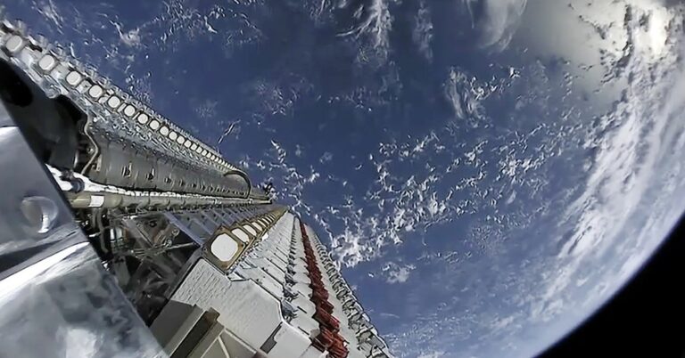 A stack of Starlink satellites atop a Falcon 9 rocket above Earth.