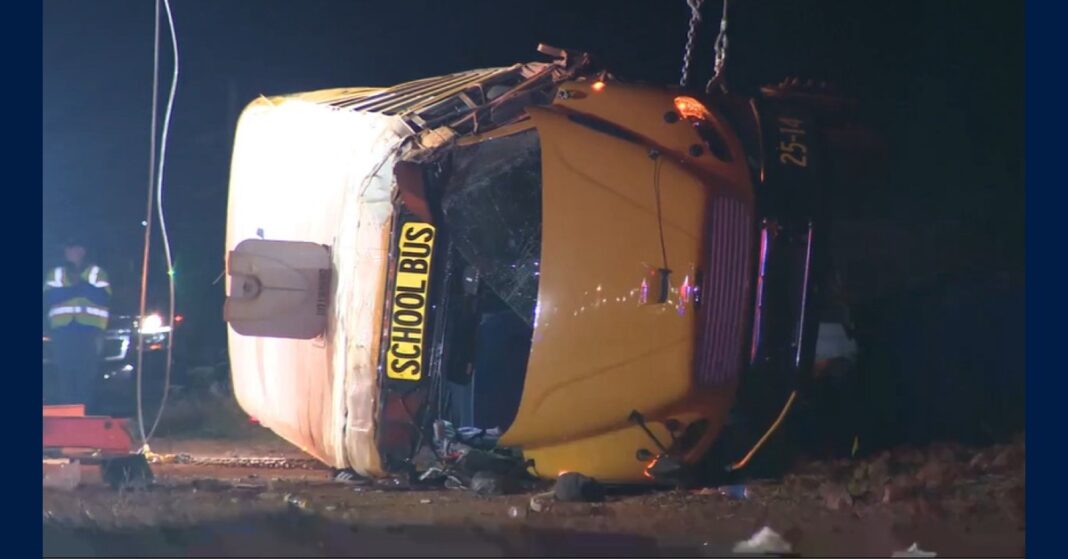 Salem High School bus crash scene showing a yellow school bus lying on its side at night.