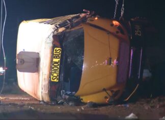 25 Taken to Hospitals After Salem High Football Bus Overturns Salem High School bus crash scene showing a yellow school bus lying on its side at night.