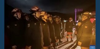 Firefighters with the Xizang fire and rescue service line up for a nighttime briefing during the earthquake response in Nagqu, Tibet.