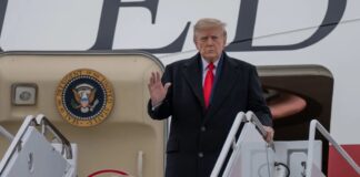 President Donald Trump waves as he boards Air Force One