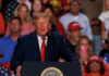 President Donald Trump speaks at a podium during a rally at Freeman Coliseum in San Antonio.