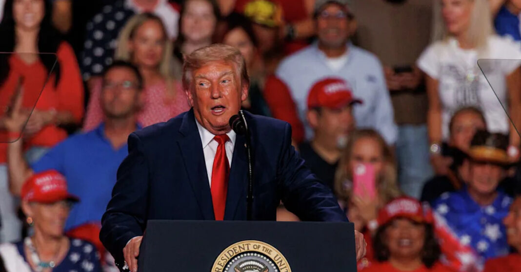 President Donald Trump speaks at a podium during a rally at Freeman Coliseum in San Antonio.