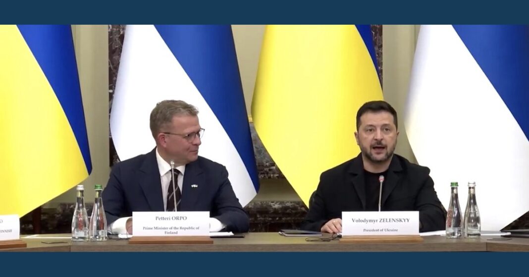 Petteri Orpo and Volodymyr Zelenskyy seated before Finnish and Ukrainian flags at a news conference on Ukraine-Finland cooperation.