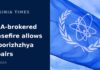 IAEA-Brokered Ceasefire Allows Repairs Near Ukraine Nuclear Plant The flag of the International Atomic Energy Agency flying against a blue sky during the Zaporizhzhya nuclear plant ceasefire in Ukraine.