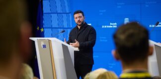 Ukrainian President Volodymyr Zelenskyy speaking at a podium in Brussels during the European Council meeting, 15-16 October 2026