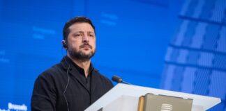 Ukrainian President Volodymyr Zelenskyy at a lectern with an EU emblem, accompanying coverage of Zelenskyy on Putin and negotiations.